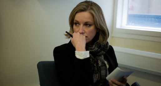 Woman sitting in a waiting room with a worried look.