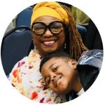 Deborah Ogiste smiling with her young grandson