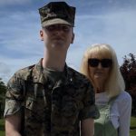 Ethan McCall wearing Marine camouflage and smiling with his aunt. 
