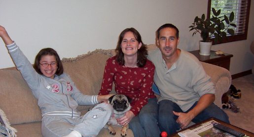 Tween sitting on couch with two adults and a pug