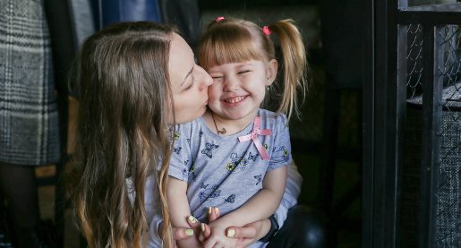 Woman give toddler kiss on the cheek