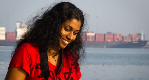 young woman smiling water in background