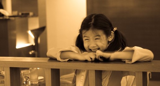 young girl standing at rail laughing