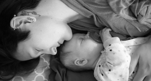woman with short hair lying next to infant