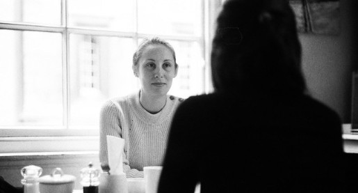 two women talking with one woman in shadow